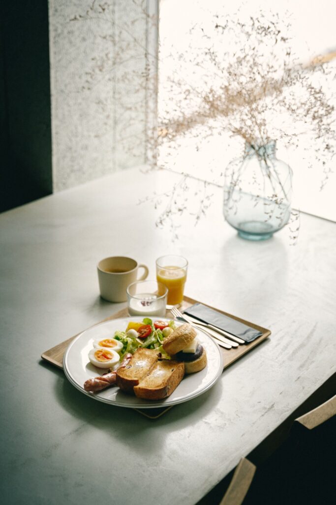 もっちりしたレーズン食パンのトーストにサラダ、ゆで卵、ソーセージ、オレンジジュース、コーヒー。自家製ヨーグルトに無農薬ルバーブでつくったジャムを添えて。¥1760。 | もっちりしたレーズン食パンのトーストにサラダ、ゆで卵、ソーセージ、オレンジジュース、コーヒー。自家製ヨーグルトに無農薬ルバーブで作ったジャムを添えて。¥1,760。