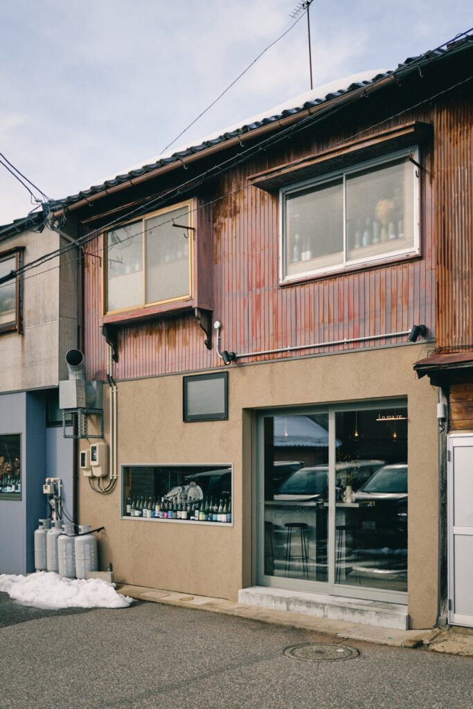 築100年ほどの古民家を改装し、シンプルな外観の店舗。窓際に並べられた空きボトルが目印。 | 築100年ほどの古民家を改装したシンプルな外観の店舗。窓際に並べられた空きボトルが目印。