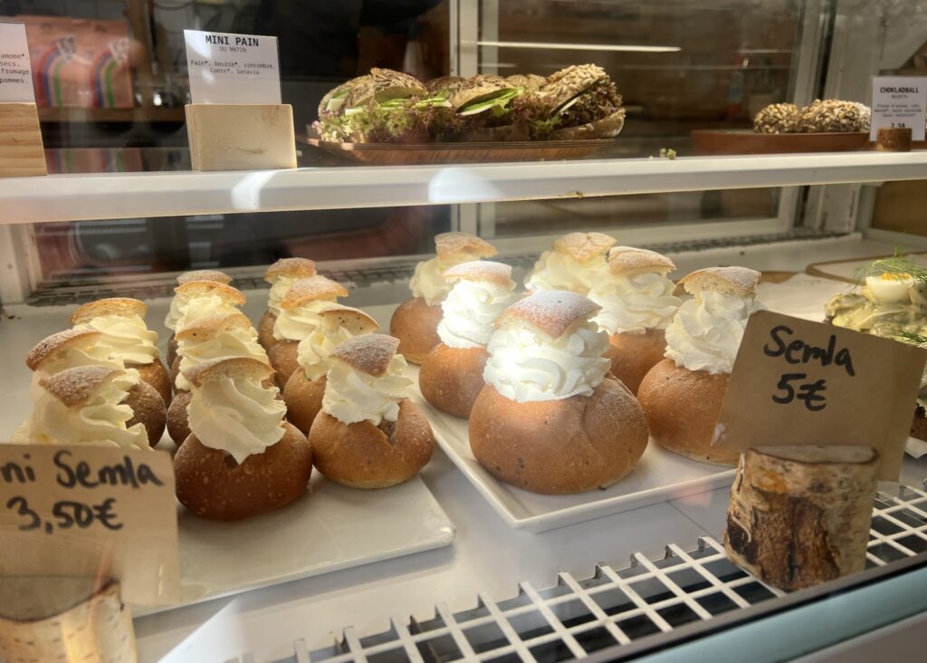 『フィカ』に並ぶ、カルダモンを練り込んだパン生地を使ったスウェーデンのお菓子、セムラ。大小2つのサイズ。上の段に見えるミニサンドは朝食タイムから食べられる。 『フィカ』に並ぶ、カルダモンを練り込んだパン生地を使ったスウェーデンのお菓子、セムラ。大小2つのサイズ。上の段に見えるミニサンドは朝食タイムから食べられる。