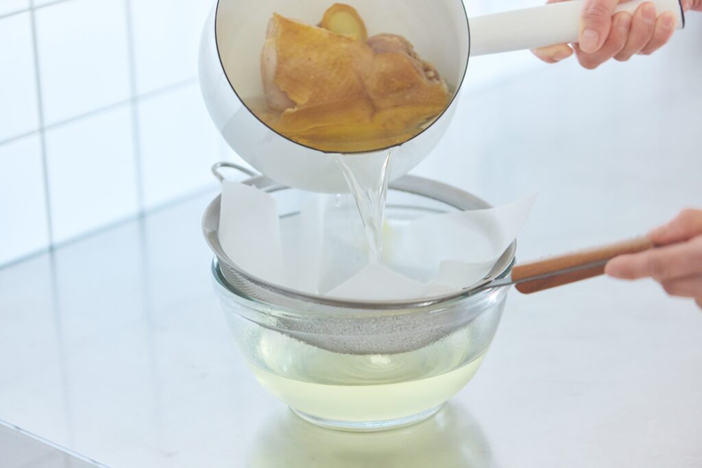 〈POINT〉鶏肉をじっくり煮込んで出汁を取り、「リード クッキングペーパー」で濾す。細かいクズなどをキャッチしながら素早くろ過でき、驚くほど澄んだ黄金色のスープに。