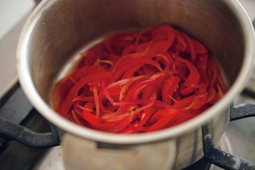 &CookingM_p006-053_献立編_23 | ドレッシングの役割を担う赤玉ネギと赤
パプリカのマリネは小鍋で作る。