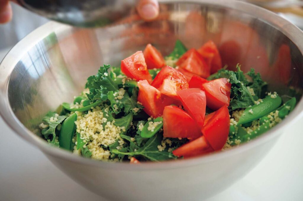 &CookingM_p006-053_献立編_27 | 大きめのボウルでクスクスを蒸らしてお
き、その中に野菜や肉を加えていく。