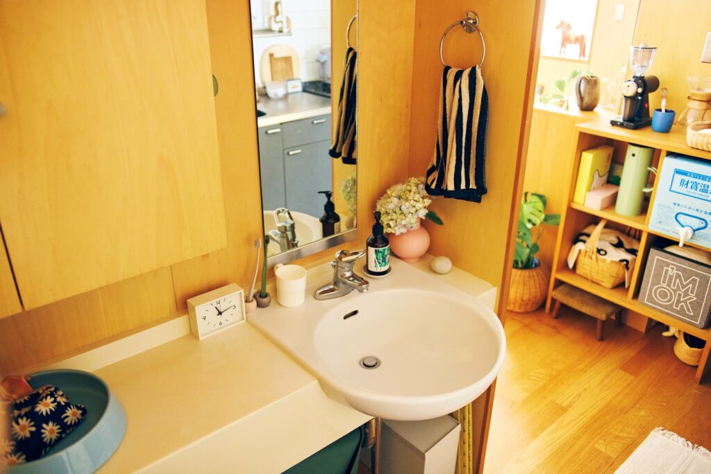 ダイニングルームと水回りを隔てる仕切りの裏には、備え付けの小ぶりな洗面台が。夏海さんが生ける花々が、ささやかな彩りを添えている。