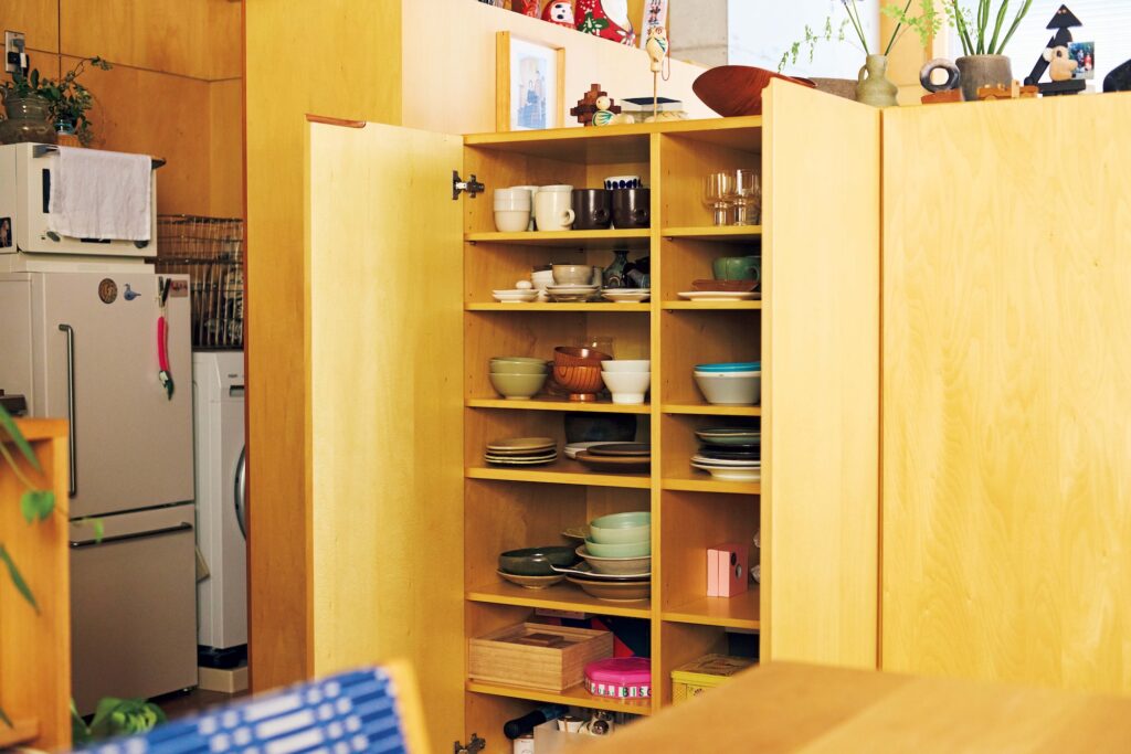 ベッドスペースとダイニングルームの間仕切りになるように配置されている可動式収納。扉ごとに用途を分け、食器などの日々よく使うものが収められている。