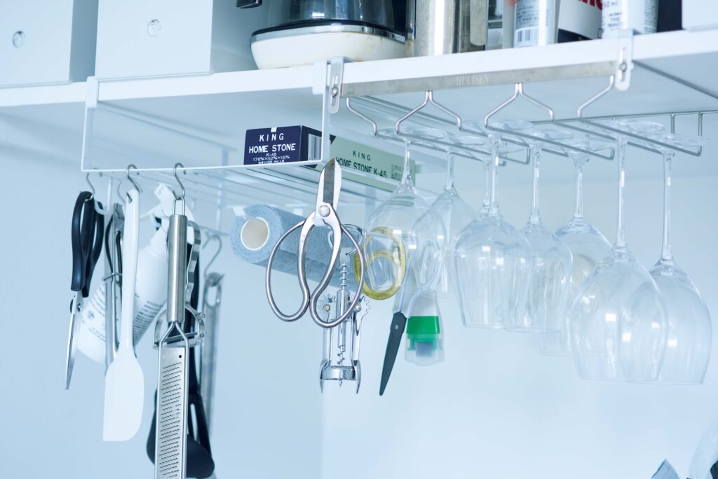 台所道具やグラスは吊るして収納。コンクリートブロックとステンレス仕様のオープンキッチンに立ち、部屋を眺めながら料理をするのが楽しいそうだ。