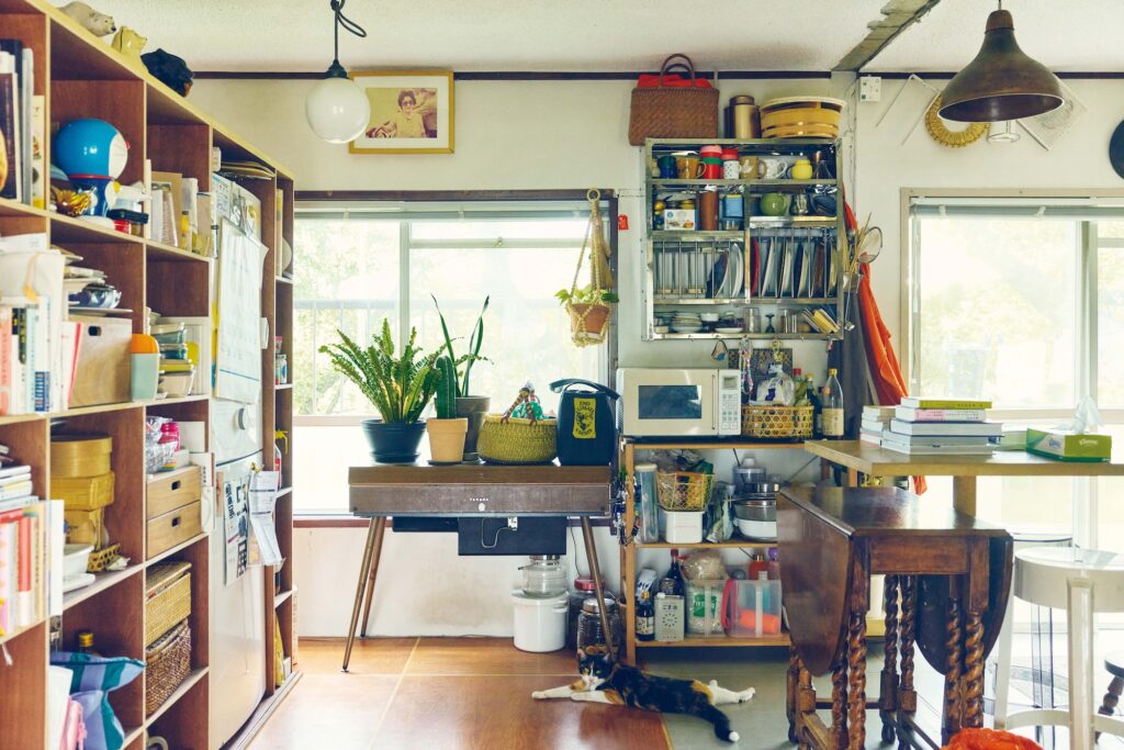 本棚の右端の一部に冷蔵庫や日用品を収納。「木材が多くなりすぎないように壁にステンレススチールの食器棚を設え、見せながら整理しました」