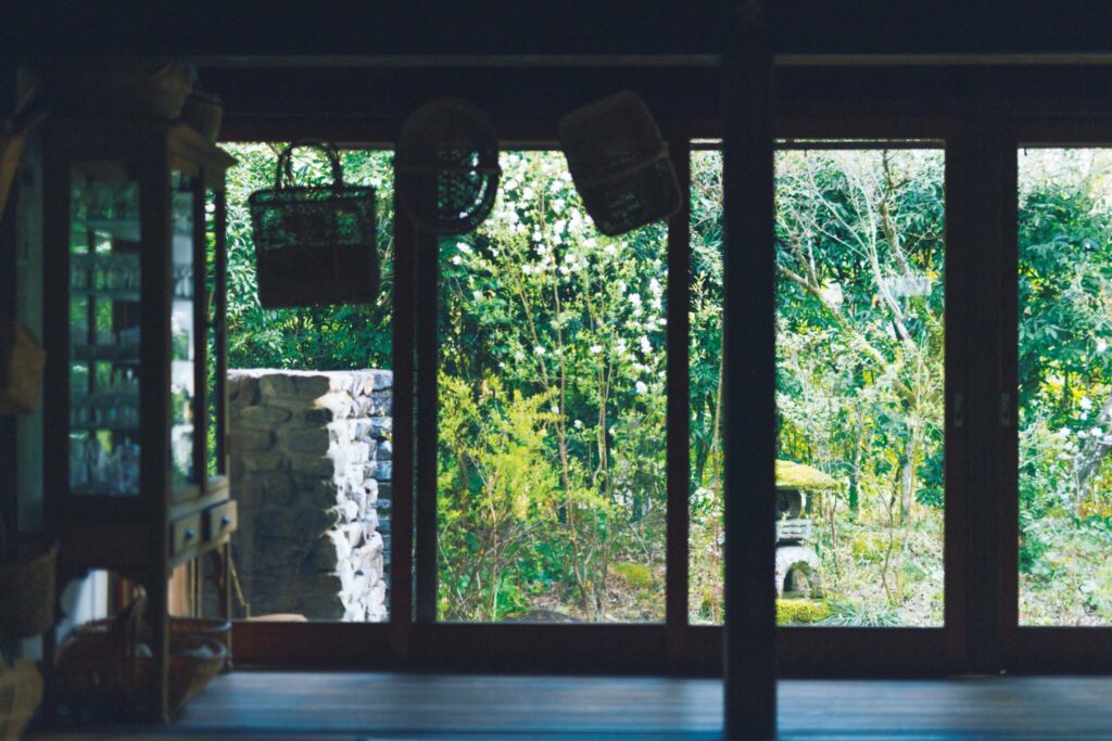 ダイニングから望む春の庭。濃緑の樹々に、利休梅の白が凛と浮かびあがる。四季折々、部屋から眺める景色をイメージしながら植え込む場所を決めている。