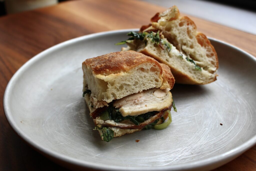 本誌で紹介した、ポルケッタサンド。“schiacciata (スキアッチャータ) ”とメニューに書かれていた。トスカーナ発祥の平たいフォカッチャのことだそう。 川村明子