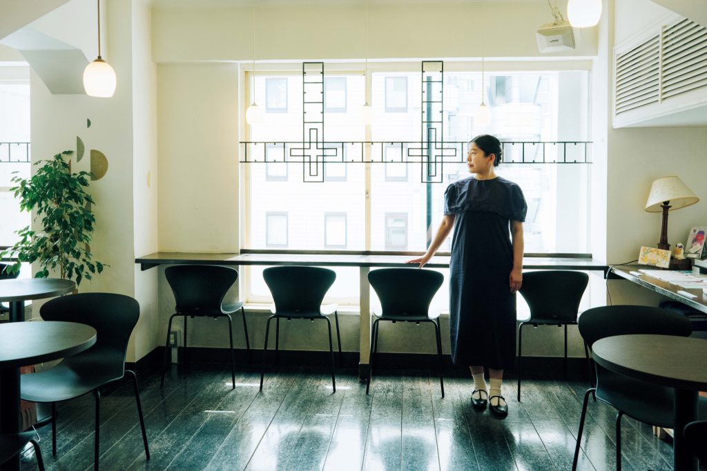 文筆家・甲斐みのりさんに聞いた、いい仕事をするために大切にしていること。アントニン・レーモンドが設計を手がけた銀座「教文館ビル」の4階『CAFÉきょうぶんかん』にて。「窓辺に配した十字架のアイアンワークが素敵」 | アントニン・レーモンドが設計を手がけた銀座「教文館ビル」の4階『CAFÉきょうぶんかん』にて。「窓辺に配した十字架のアイアンワークが素敵」