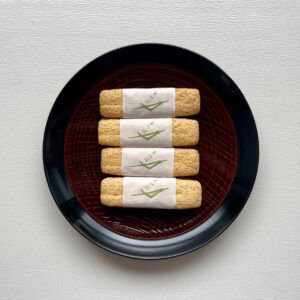 品のいい松葉の形のお菓子、『宝泉堂』の千代木。京都好きでわらび餅好きの友人に誘われて伺ったのが、『茶寮 宝泉』。 実は私もわらび餅好きゆえ、行きつけはあるにはあるのだが、友人が日本一というので、喜び勇んで出かけた。整えられた美しいお庭を見ながらのティータイムは、いい雰囲気。わらび餅ももちろんおいしくいただいた。 帰りがけにショップをのぞくと、おしゃれな和の缶が。早速買い求めたところ、これがまぁ、お品がよろしい。缶の中には、松葉の形 (といっても、よく見ればだけど) のぼうろが２本、美しい紙に巻かれて10組鎮座する。千代木とは松のことだそうで、「永遠に変わらない」象徴。とにもかくにもめでたいお菓子だ。おいしいお茶とゆっくりいただきたいが、コーヒーとも相性がいい。
