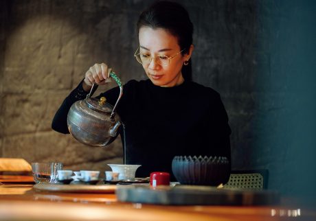 琥珀色のモダンなカウンター席で、半世紀寝かせた凍頂烏龍茶を味わう。 | 「若い世代や海外の人にも台湾茶の文化をわかりやすく伝えたい」と語るカレンさん。2019年に開業し、現在も上質な茶葉を探し求め、産地や茶農家を訪ね歩いている。