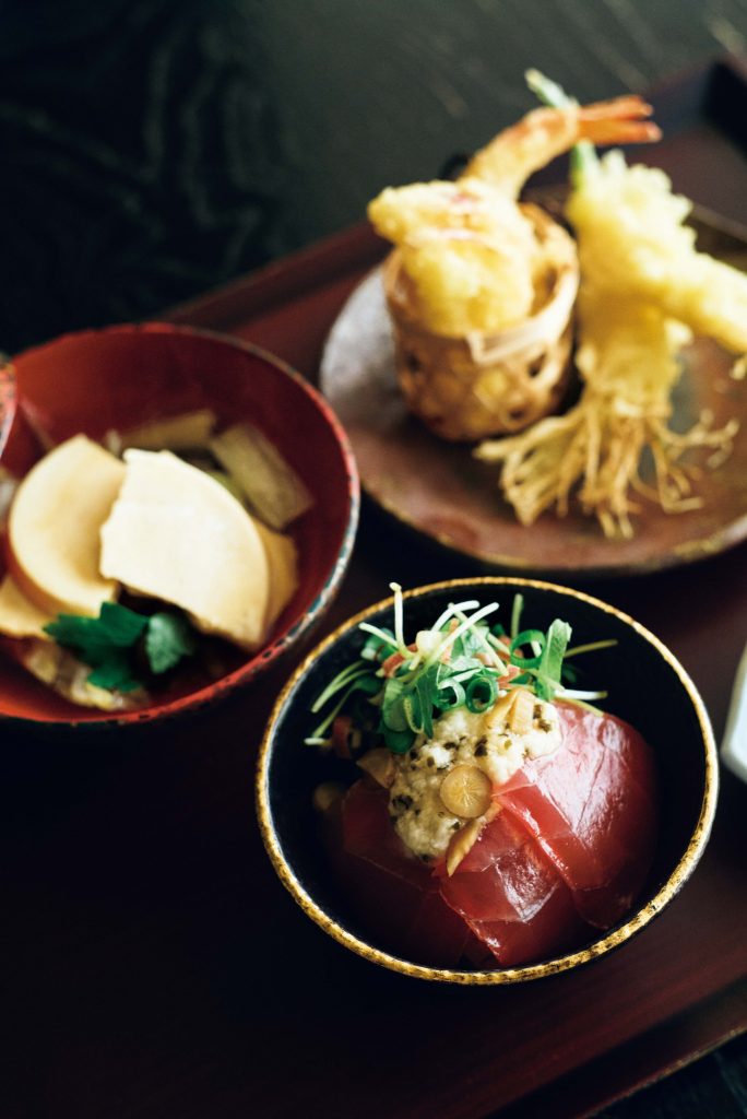 ビュッフェ「のれそれ食堂」より、手前から、マグロの漬けまんま、せんべい汁、りんごとエビ、にんにくの天ぷら。あたたかな伝統文化ともてなしに触れる。穏やかな時間が流れる『青森屋』へ。坂本美雨さんと巡る、青森への旅。 | ビュッフェ「のれそれ食堂」より、手前から、マグロの漬けまんま、せんべい汁、りんごとエビ、にんにくの天ぷら。