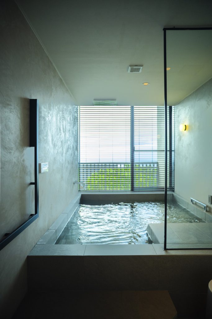 ジュニアスイートのお風呂は、幅広の寝湯バスタブ。運び湯した「屋久島温泉」を24時間楽しめる。