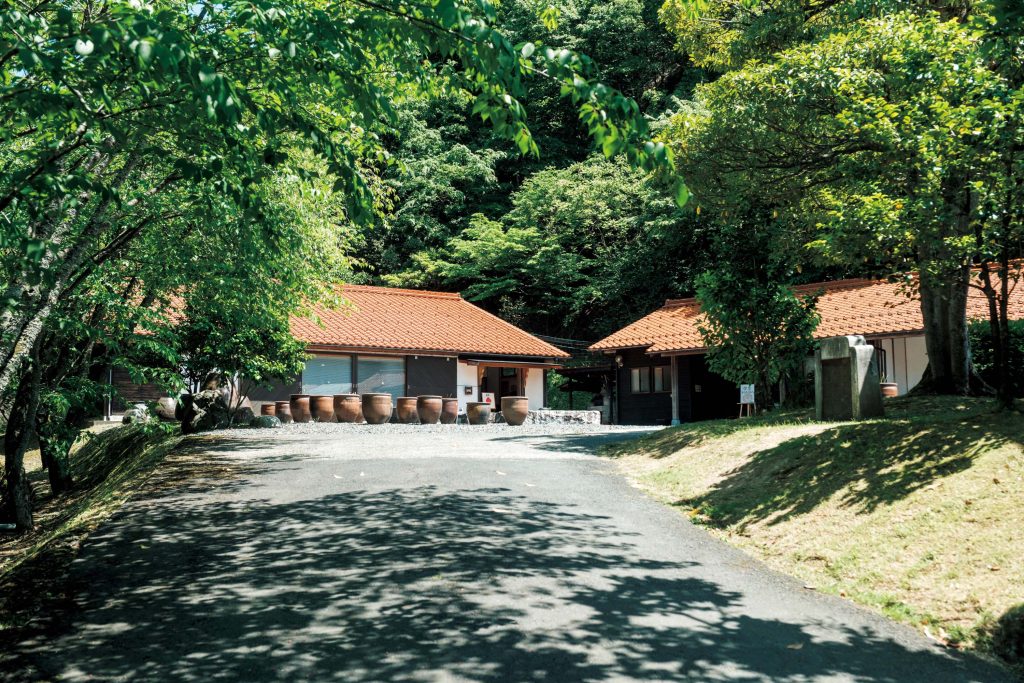手仕事を辿る旅。鳥取・鳥取〜倉吉古き良き風情が残る岩井温泉近くの山あいに佇む『クラフト館 岩井窯』（岩美町宇治134‒1）は、1971年、陶芸家の山本教行さんが開窯。作品を展示販売する「作品展示館」、岩井窯の器で食事を楽しめる「喫茶HANA」、工芸資料を展示する「参考館」が並ぶ。庭に置かれた甕(かめ)には蓮が植えられていた。 | クラフト館 岩井窯　古き良き風情が残る岩井温泉近くの山あいに佇む『クラフト館 岩井窯』（岩美町宇治134‒1）は、1971年、陶芸家の山本教行さんが開窯。作品を展示販売する「作品展示館」、岩井窯の器で食事を楽しめる「喫茶HANA」、工芸資料を展示する「参考館」が並ぶ。庭に置かれた甕(かめ)には蓮が植えられていた。
