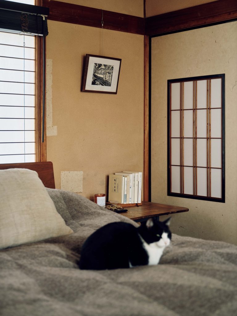 自分たちらしい空間に、家を育てていく。『hitonoto』店主・安田奈央さんとビデオグラファー・ニック・ヴァン・デル・ギーセンさんの築60年のお家。 | 〝障子事件〞の悪気のない犯人（猫）、おとちゃん。後ろにあるのは、古道具屋で見つけた街並みが刷られた木版画。