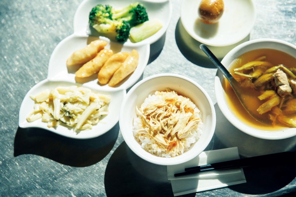 梁記雞肉飯の金針赤肉湯（チンツェンツーロウタン） | 鶏肉飯に小鉢と煮卵が付いている定食120元。小鉢は上から、茹でブロッコリー、さつま揚げ、たけのこ炒め。右のスープは、醤油ベースの豚骨スープに豚の赤身肉、金針菜の漬物が入った金針赤肉湯（チンツェンツーロウタン）60元。