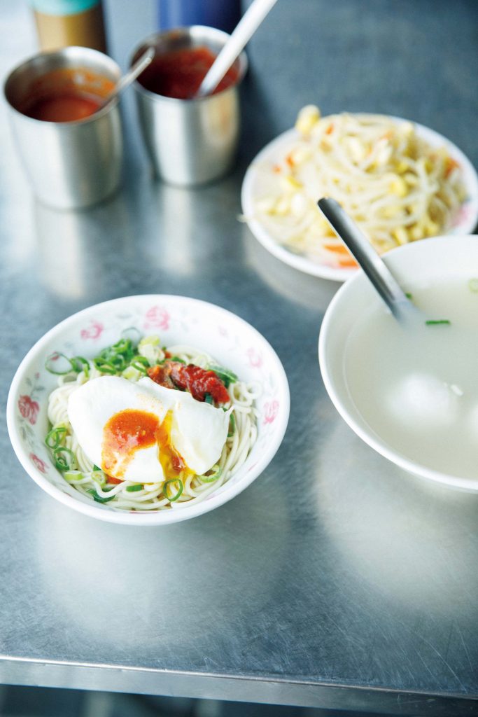 香り高い麺を気軽に。長く愛されてきた味を受け継ぐ人気店へ。乾麵(小)37元。右は豚骨とエビのだしが効いた蛋包魚丸湯(タンパオユィワンタン)45元。「汁なしの合え麺とスープを一緒に注文するのが定番。スープの中 の卵を麺に移して食べるのが通の食べ方」と案内人の洪愛珠さん。 | 乾麵(小)37元。右は豚骨とエビのだしが効いた蛋包魚丸湯(タンパオユィワンタン)45元。「汁なしの合え麺とスープを一緒に注文するのが定番。スープの中
の卵を麺に移して食べるのが通の食べ方」と案内人の洪愛珠さん。 香り高い麺を気軽に。長く愛されてきた味を受け継ぐ人気店へ。乾麵(小)37元。右は豚骨とエビのだしが効いた蛋包魚丸湯(タンパオユィワンタン)45元。「汁なしの合え麺とスープを一緒に注文するのが定番。スープの中 の卵を麺に移して食べるのが通の食べ方」と案内人の洪愛珠さん。