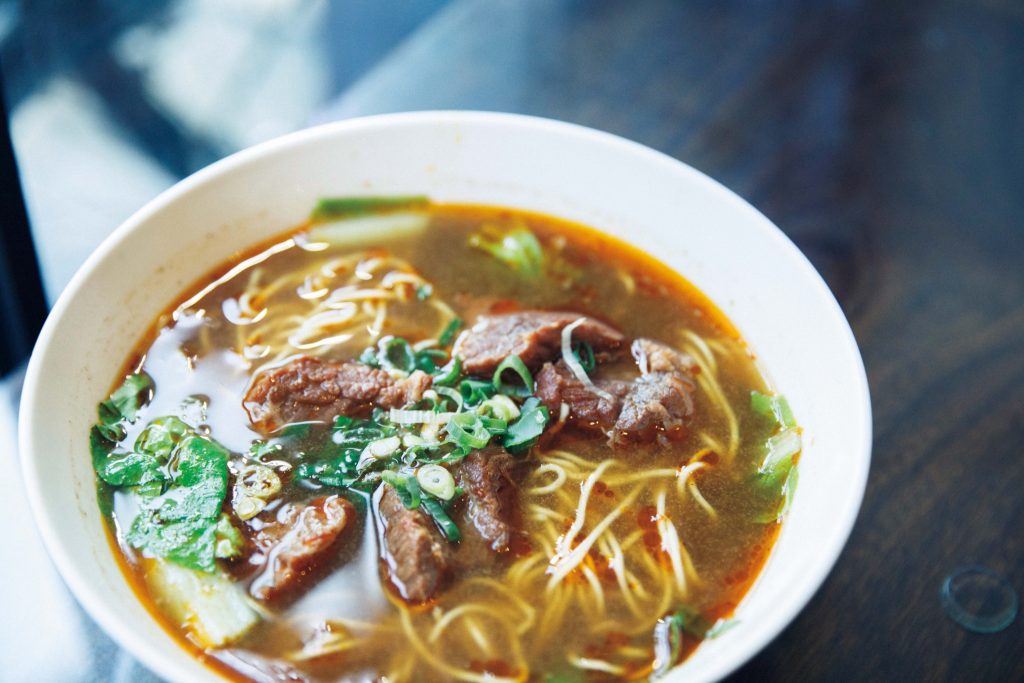 香り高い麺を気軽に。長く愛されてきた味を受け継ぐ人気店へ。紅焼牛肉麵(ホンシャオニョウロウミエン)220元。牛骨スープに麻辣スープを混ぜた、程よい辛さ。豆板醤をベースとした麻辣スープで自家製ラー油、6種の生薬、金柑、パイナップルなどとともに煮込まれた牛肉は、スパイスが染み込んだ香り高い味。 | 紅焼牛肉麵(ホンシャオニョウロウミエン)220元。牛骨スープに麻辣スープを混ぜた、程よい辛さ。豆板醤をベースとした麻辣スープで自家製ラー油、6種の生薬、金柑、パイナップルなどとともに煮込まれた牛肉は、スパイスが染み込んだ香り高い味。 香り高い麺を気軽に。長く愛されてきた味を受け継ぐ人気店へ。紅焼牛肉麵(ホンシャオニョウロウミエン)220元。牛骨スープに麻辣スープを混ぜた、程よい辛さ。豆板醤をベースとした麻辣スープで自家製ラー油、6種の生薬、金柑、パイナップルなどとともに煮込まれた牛肉は、スパイスが染み込んだ香り高い味。 | 紅焼牛肉麵(ホンシャオニョウロウミエン)220元。牛骨スープに麻辣スープを混ぜた、程よい辛さ。豆板醤をベースとした麻辣スープで自家製ラー油、6種の生薬、金柑、パイナップルなどとともに煮込まれた牛肉は、スパイスが染み込んだ香り高い味。