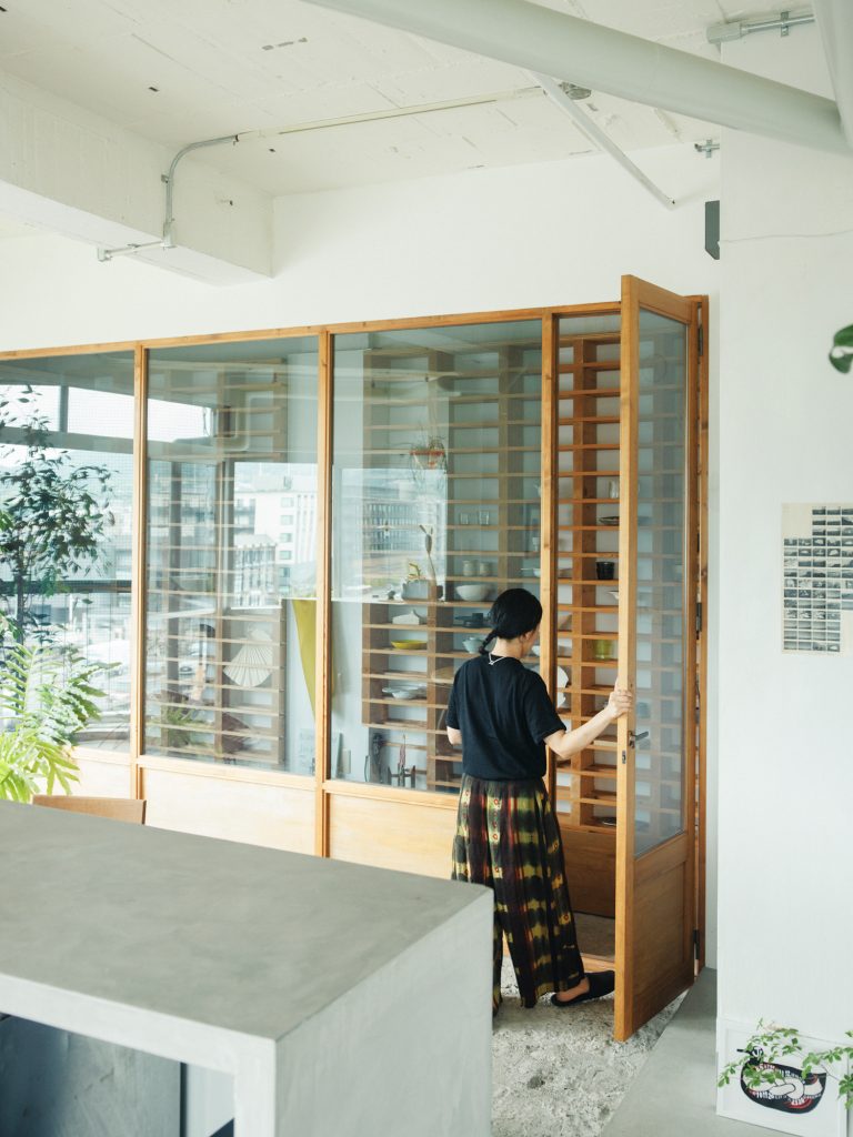 かつてワインバーだった一室を住居として借り受けた、カフェオーナーの原こころさん。残されたワインセラーを生かし、器や日用品の収納棚に。