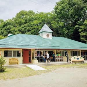 山梨・上野原にあるミニシアター『CineYama』の外観 | 閉園し、朽ち始めていた幼稚園を蘇らせた小さな映画館『CineYama』。園庭にはテーブル、ベンチ、遊具が並ぶ。