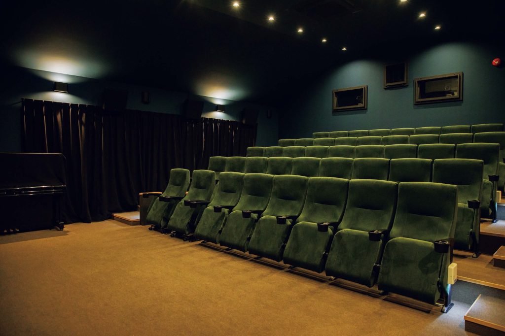 かつて幼稚園だった場所をミニシアターとしてオープン。山梨・上野原『CineYama』。「夜の森」をイメージした劇場。深い苔色のシート、トワイライトブルーの天井、温かみのある間接照明で静かな没入のための場所に仕上げた。 | 「夜の森」をイメージした劇場。深い苔色のシート、トワイライトブルーの天井、温かみのある間接照明で静かな没入のための場所に仕上げた。