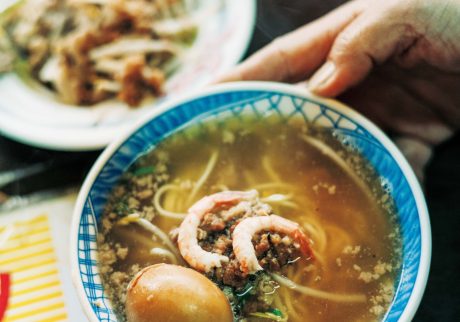 老若男女に愛される、地元ならではの味。台南フードを味わう。台南発祥の担仔麺（タンツァイミエン）小60元。すりおろし生ニンニク、パクチー、エビなどをトッピング。「栄養たっぷりな煮卵（15元）も欠かせません」と案内人で『蘿拉冷飲店 LOLA』オーナーのジンジンさん。 | 台南発祥の担仔麺（タンツァイミエン）小60元。すりおろし生ニンニク、パクチー、エビなどをトッピング。「栄養たっぷりな煮卵（15元）も欠かせません」と案内人で『蘿拉冷飲店 LOLA』オーナーのジンジンさん。