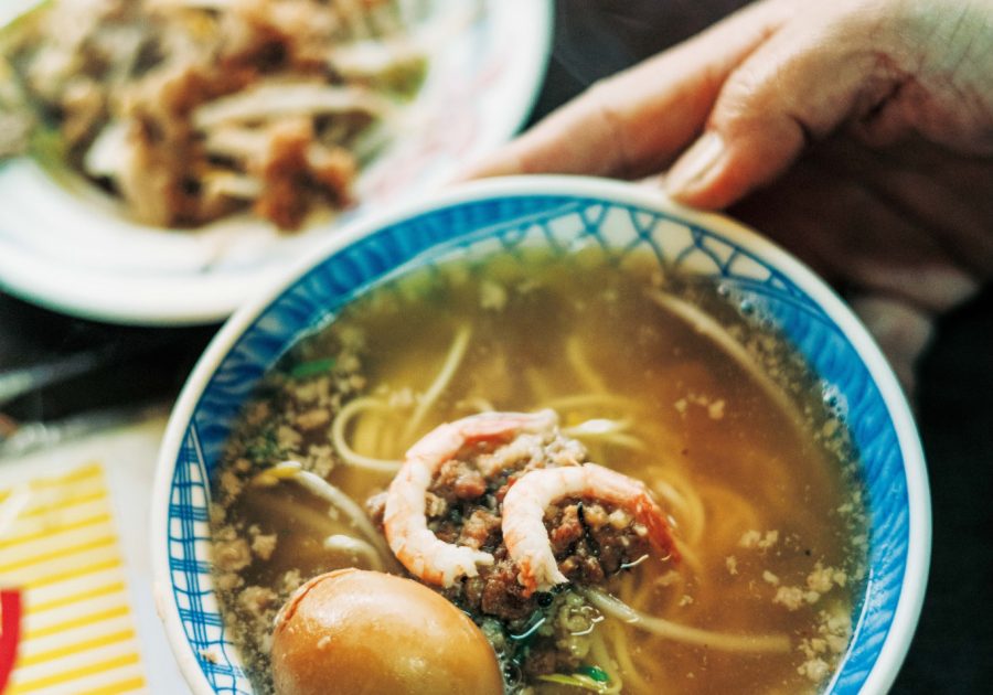 老若男女に愛される、地元ならではの味。台南フードを味わう。台南発祥の担仔麺（タンツァイミエン）小60元。すりおろし生ニンニク、パクチー、エビなどをトッピング。「栄養たっぷりな煮卵（15元）も欠かせません」と案内人で『蘿拉冷飲店 LOLA』オーナーのジンジンさん。 | 台南発祥の担仔麺（タンツァイミエン）小60元。すりおろし生ニンニク、パクチー、エビなどをトッピング。「栄養たっぷりな煮卵（15元）も欠かせません」と案内人で『蘿拉冷飲店 LOLA』オーナーのジンジンさん。