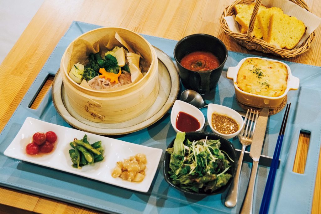 『青い星通信社』で提供される北海道の食材を生かした夕食 | 『青い星通信社』で提供される北海道の食材を生かした夕食。北棟ライブラリーに用意されたカウンター席とテーブル席で食すことができる。朝食もあり。