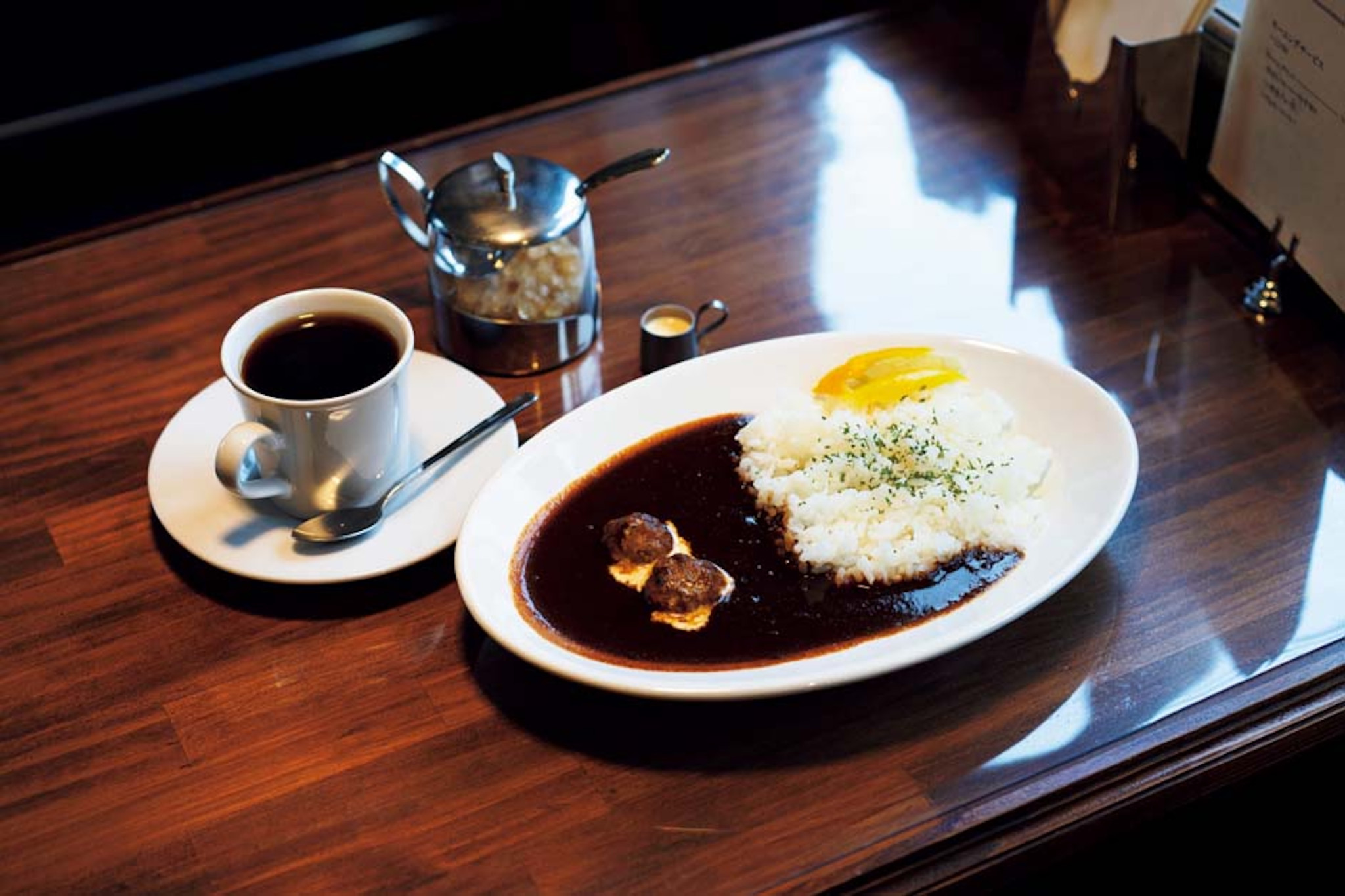 京都・一乗寺 『喫茶 霧箱』 ハヤシライス&コーヒーセット | 「ランチは『喫茶 霧箱』で食べることも多くて。ハヤシライスもトーストもおいしい。明るい店内で本棚の漫画を読むのも楽しみ」と日髙さん。ミニハンバーグ入りで、コクと苦味が食欲をそそるハヤシライス&コーヒーセット(¥1,200)。 京都・一乗寺 『喫茶 霧箱』 ハヤシライス&コーヒーセット | 「ランチは『喫茶 霧箱』で食べることも多くて。ハヤシライスもトーストもおいしい。明るい店内で本棚の漫画を読むのも楽しみ」と日髙さん。ミニハンバーグ入りで、コクと苦味が食欲をそそるハヤシライス&コーヒーセット(¥1,200)。