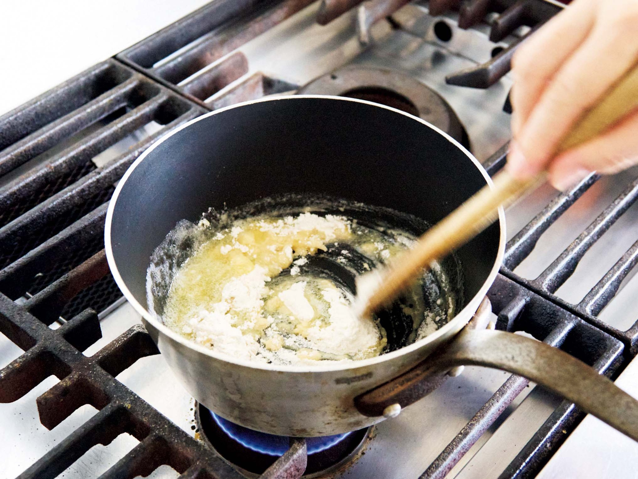 本気のグラタンを作る。ソースも具もひと手間かけて。 湯気まで味わう、ごちそう。まずは小麦粉を炒める。少し弱めの中火で沸騰させながら混ぜると艶のあるソースになる。焦げないように手は休めずに。 | まずは小麦粉を炒める。少し弱めの中火で沸騰させながら混ぜると艶のあるソースになる。焦げないように手は休めずに。