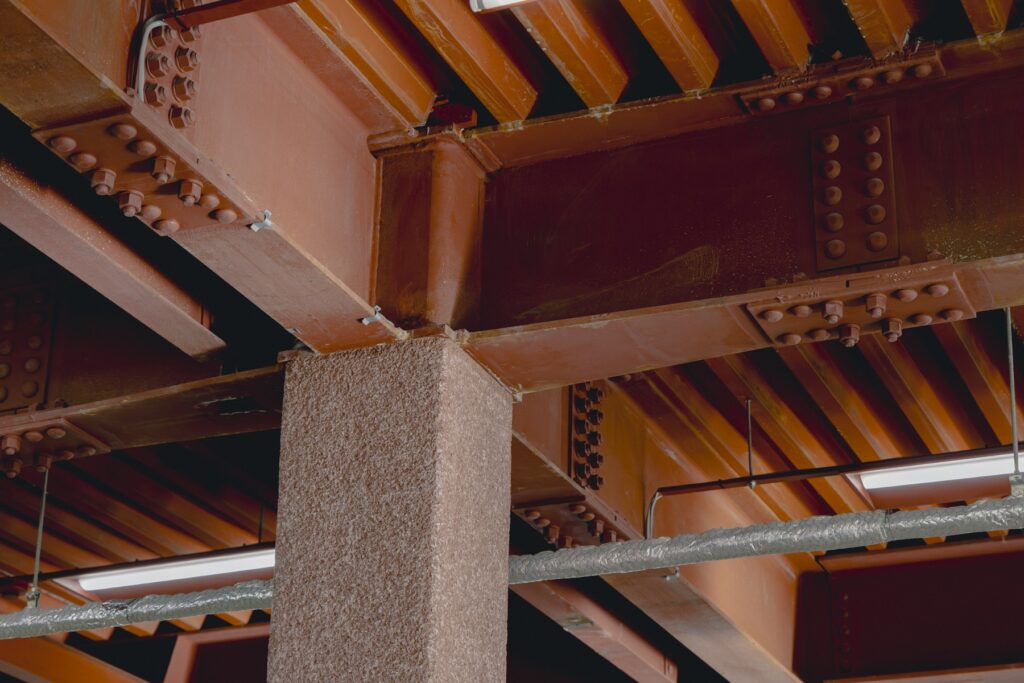 靴から、暮らしがひらく場所。〈ムーンスター〉が発祥の地、福岡・久留米に新店舗『PLATO MOONSTAR』をオープン。 | 鉄骨の朱色に合わせて塗り付けられた柱は、左官掻き落としを研磨して仕上げている。