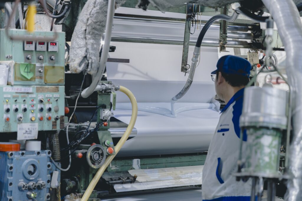 靴から、暮らしがひらく場所。〈ムーンスター〉が発祥の地、福岡・久留米に新店舗『PLATO MOONSTAR』をオープン。 | アッパーの表布と裏布を接着剤で貼り合わせる。液状のゴム糊を使うことで、より接着強度が増すという。